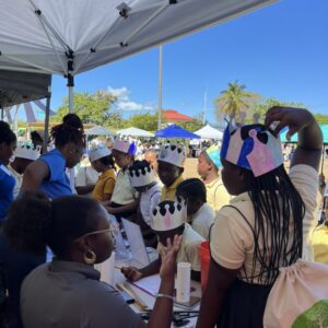 Children wearing paper crowns at outdoor booth